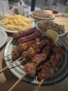 a plate of food with meat and french fries at Blue Marianthi in Ávdhira