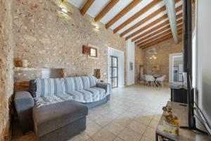 a living room with a couch and a stone wall at Villa Biniali Costitx in Costitx
