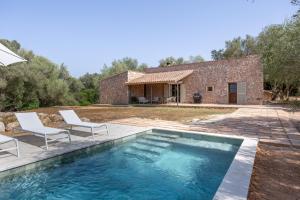 a house with a pool and two chairs and a building at Villa Biniali Costitx in Costitx