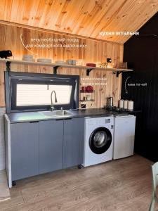 eine Küche mit Waschmaschine und Spüle in der Unterkunft Barn 25 in Chornomors'ke