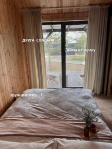ein Bett in einem Zimmer mit einem großen Fenster in der Unterkunft Barn 25 in Chornomors'ke + 21 Fotos