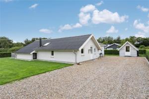 a white house with a black roof on a gravel driveway at LF12172-Vinderup-Strandlyst-29 in Vinderup