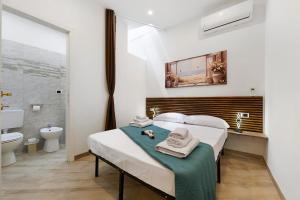 a bedroom with a bed with towels on it at Bikers Rooms in Sestu +55 photos