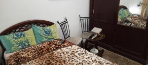 a bedroom with a bed and a chair and a mirror at Dar salam in Tunis