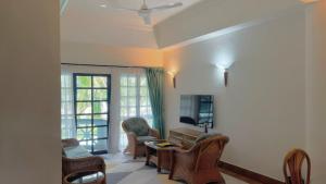 a living room with chairs and a ceiling fan at Long Sands Port Dickson in Port Dickson