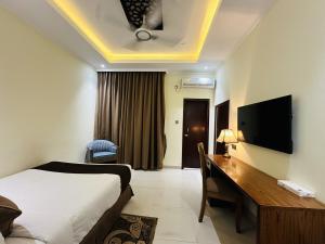 a hotel room with a bed and a desk and a television at Uni Resort in Cox's Bazar