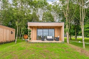 a tiny house with a porch in a yard at Tinwood Estate Vineyard Lodges in Chichester