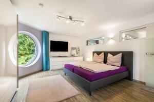 a bedroom with a large bed and a tv at Casa Wohnen und Wellness in Hemer