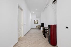 a hallway with white walls and a table with chairs at Bikers Rooms in Sestu