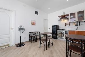 a kitchen with tables and chairs in a room at Bikers Rooms in Sestu