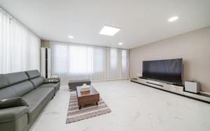 a living room with a couch and a flat screen tv at Y2 Stay Hotel in Sokcho