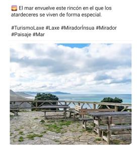 an image of benches in front of the ocean at Vivienda Turística Ático in Laxe