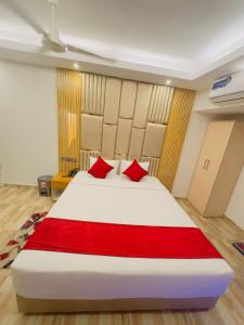 a bedroom with a large white bed with red pillows at Arham Beach Resort in Cox's Bazar
