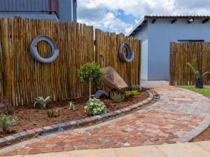 a fence with rings on it next to a garden at Tlatso lifestyle and Accommodation in Hammanskraal Station
