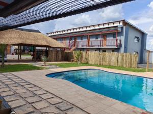 a swimming pool in front of a house at Tlatso lifestyle and Accommodation in Hammanskraal Station