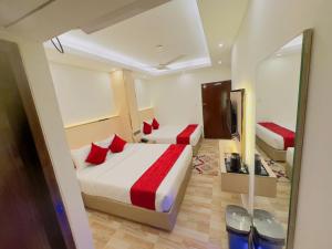 a hotel room with two beds and a mirror at Arham Beach Resort in Cox's Bazar +8 photos