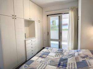 a bedroom with a bed and a large glass door at Cosy Garden Flat, Beach, Pool in Plépi +12 photos