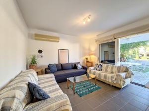a living room with two couches and a table at Cosy Garden Flat, Beach, Pool in Plépi