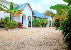 a house with trees and plants in front of it at Nahita Apartment in Kibigija