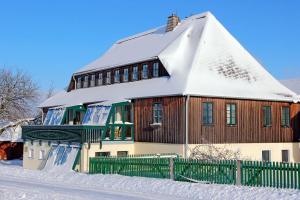a house with a snow covered roof in the snow at Ferienwohnung Bieber in Seiffen