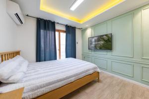 a bedroom with a bed and a flat screen tv at Yangyang Widaehan Guest in Yangyang