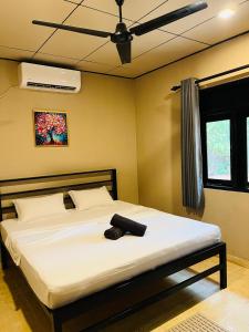 a bedroom with a large bed with a fan at Hiri Hideout in Dickwella