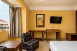a hotel room with a desk and a tv at Hotel O near RSUD Arifin Achmad formerly Damon Butik Hotel in Limbangan