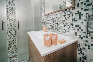 a bathroom with a sink with two bags on it at Affitta camere LUNAR in Borgo