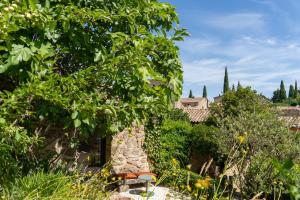a view of a garden with trees and buildings at Le Clos des Merveilles in Rognes