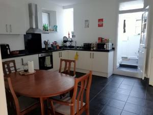 a kitchen with a wooden table and chairs and a table and a kitchen with at Miskin in Llwyn-y-pia +10 photos