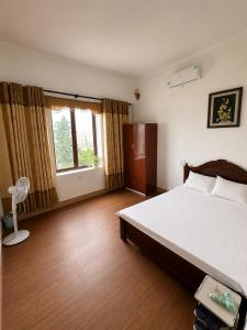 a bedroom with a large bed and a window at Nhà nghỉ Hoa Ngàn Tam Đảo in Tam Ðảo