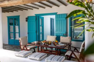 a dining room with blue doors and a table and chairs at Belogna Ikons in Vívlos