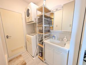 a small kitchen with a refrigerator and a sink at Maison New River B-203 in Chiharachō