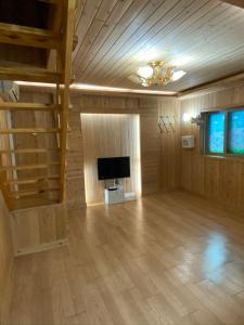 a large living room with a television and a staircase at 신화펜션 in Koryŏng