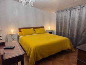 a bedroom with a bed with a yellow bedspread at Chambres à la Ferme de Pouzatel proche Bonaguil in Fumel +9 photos