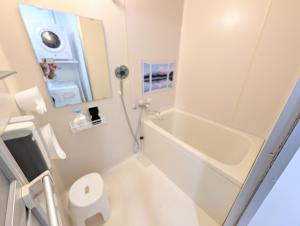 a bathroom with a tub and a toilet and a sink at Maison New River B-203 in Chiharachō