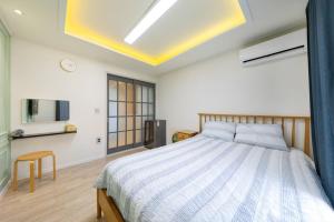 a bedroom with a large bed and a tv at Yangyang Widaehan Guest in Yangyang