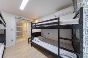 a room with two bunk beds and a hallway at Yangyang Widaehan Guest in Yangyang