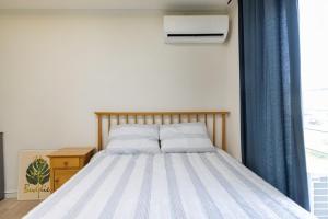 a bedroom with a bed with blue curtains and a window at Yangyang Widaehan Guest in Yangyang