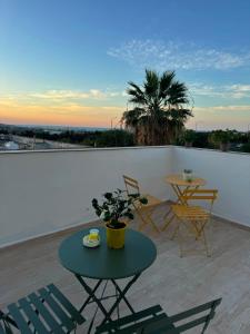 a patio with a table and chairs on a roof at Caterina Suites in Wied l-Arkata