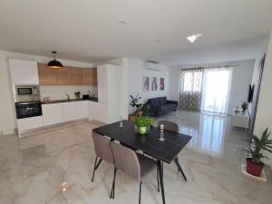a living room with a dining table and a kitchen at Caterina Suites in Wied l-Arkata