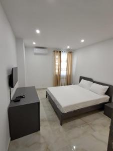 a bedroom with a bed and a television in it at Caterina Suites in Wied l-Arkata