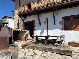 a wooden deck with a table and chairs in front of a building at Casa Nabarro in Iturgoyen