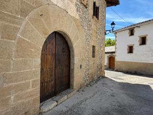 a stone building with a wooden door on it at Casa Nabarro in Iturgoyen