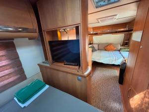 a small room with a tv and a bed at Neptun Beach Caravans in Ulcinj