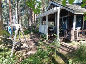 a small house with a porch in the woods at Kalliomökki in Puumala +2 photos