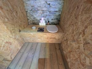a small bathroom with a toilet in a wooden room at Cabane du Serris - Expérience insolite dans les Pyrénées in Beaudéan
