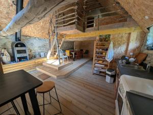 a kitchen and dining room with a wooden floor at Cabane du Serris - Expérience insolite dans les Pyrénées in Beaudéan