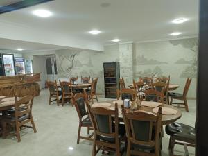 a dining room with wooden tables and chairs at Hotel Racu Family in Komrat