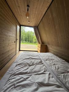 a large bed in a room with a window at Frame Village in Žaugėdai